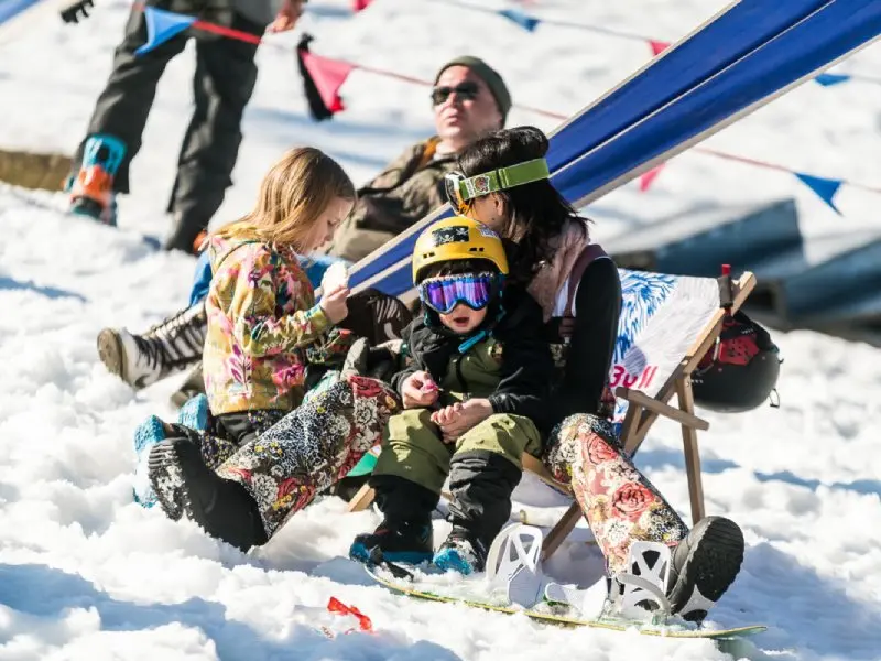 Rodzina z dziećmi wypoczywa na leżakach w zimowej atmosferze